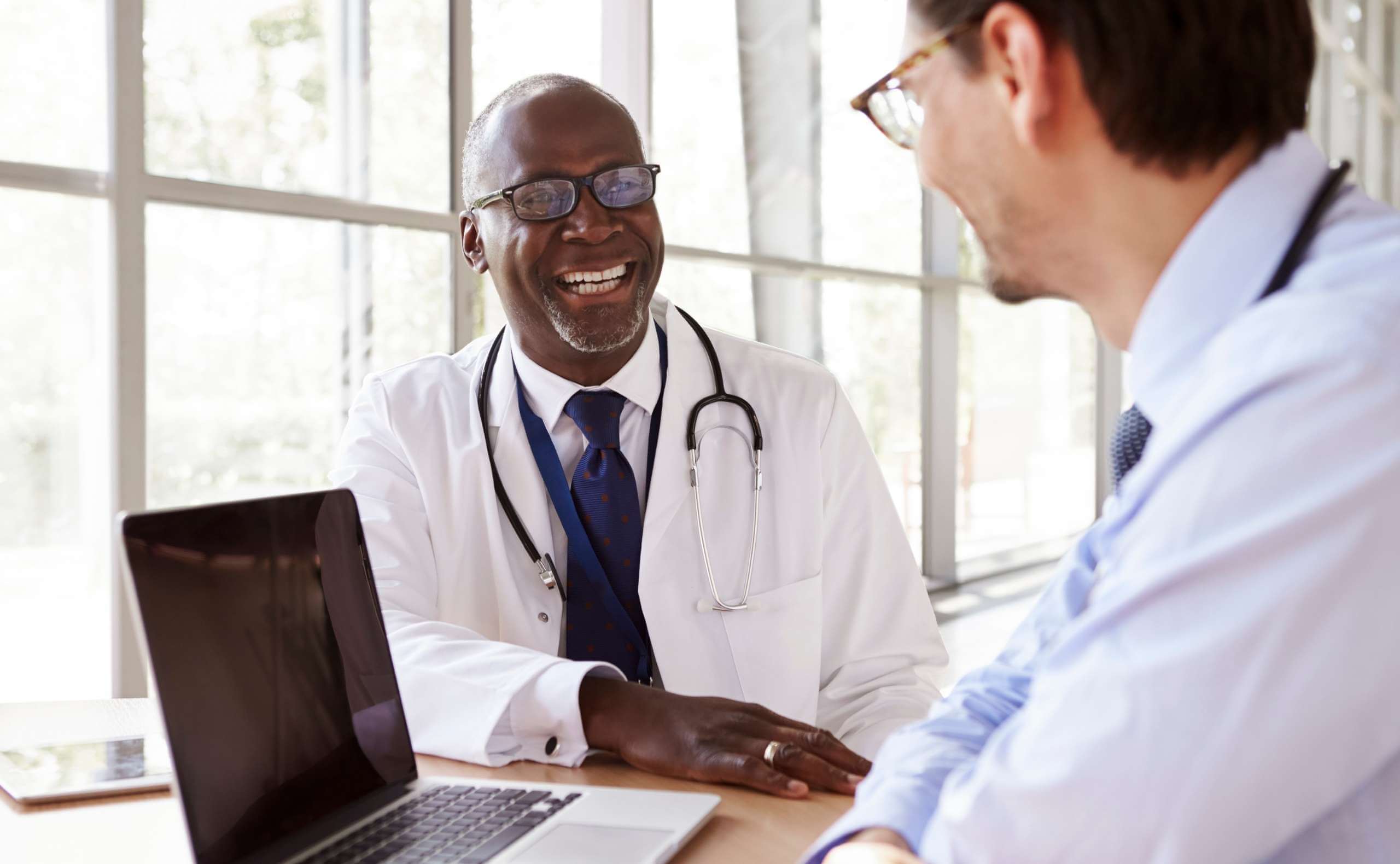 Professional healthcare IT team reviewing cybersecurity dashboards and compliance documentation in a modern office setting, representing HIPAA 2.0 updates and 2026 healthcare security readiness.